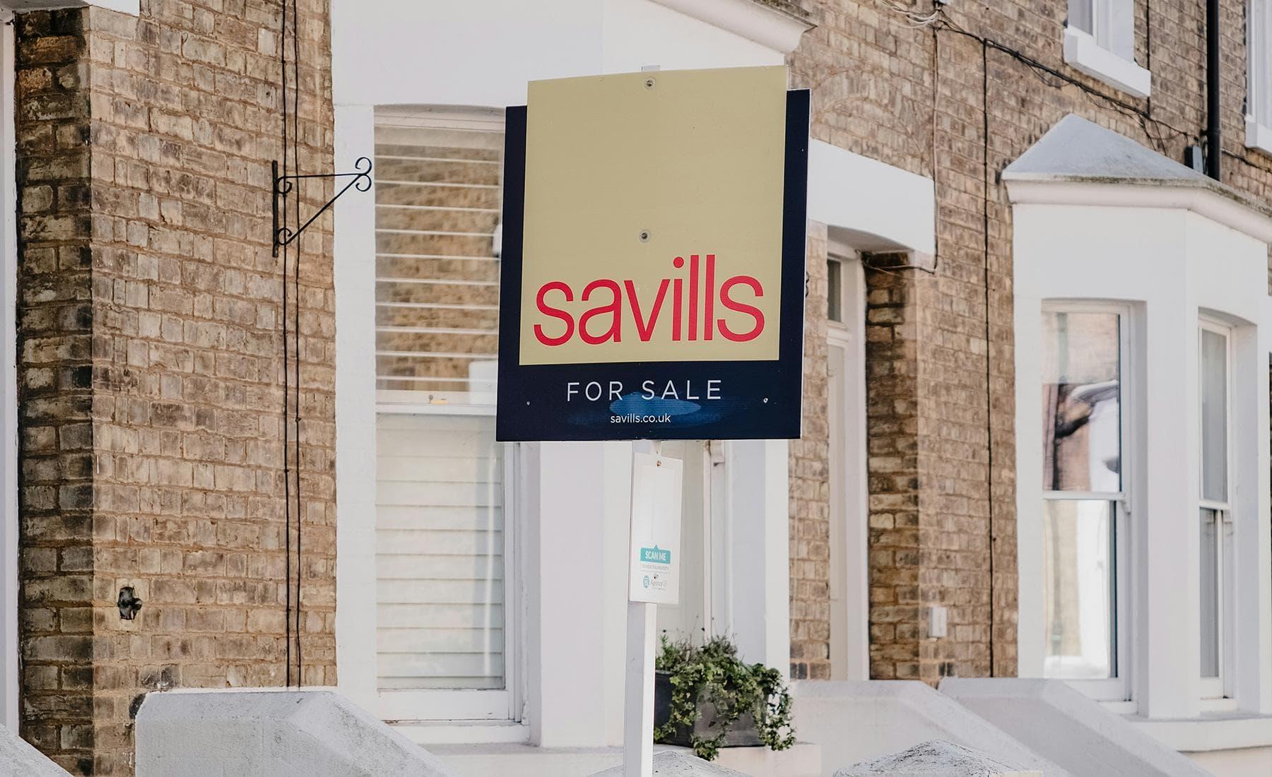 Estate agent property board displayed outside a residential home in the UK
